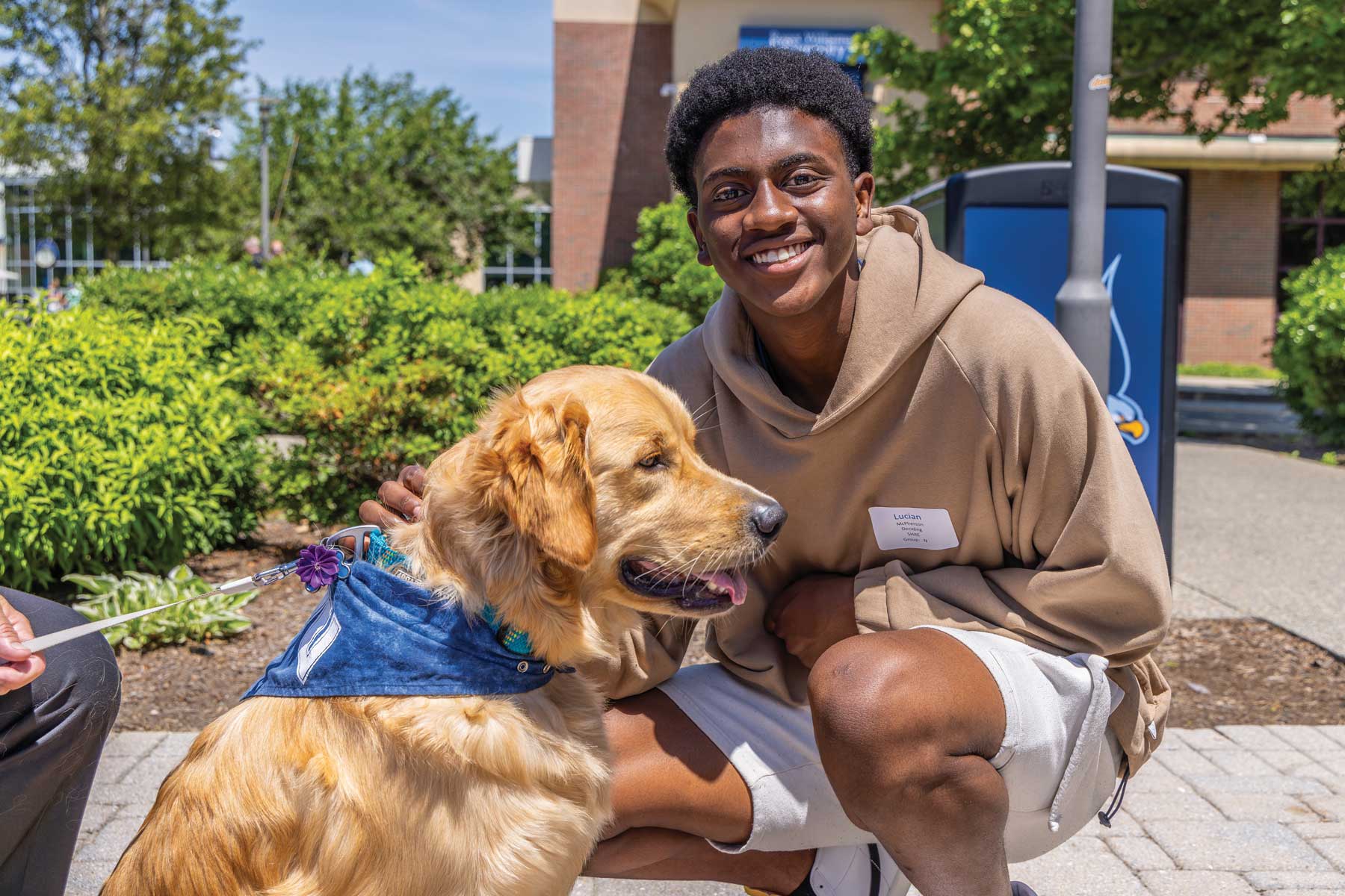 student smiling sitting next to a dog